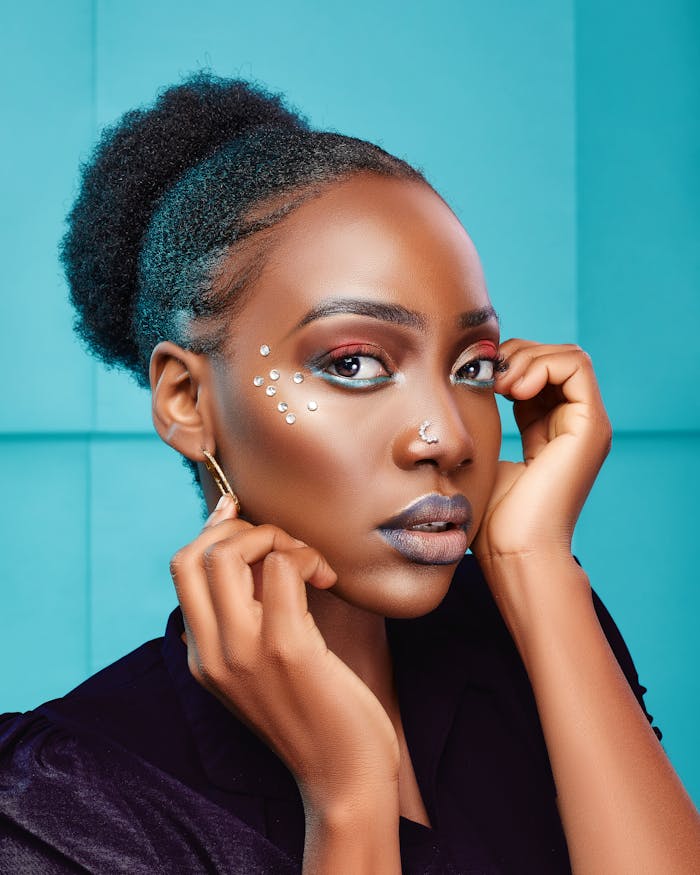 beautiful-woman-with-glamour-makeup-10722763 Stunning portrait of a stylish woman with creative makeup and hairstyle set against a vibrant blue backdrop.
